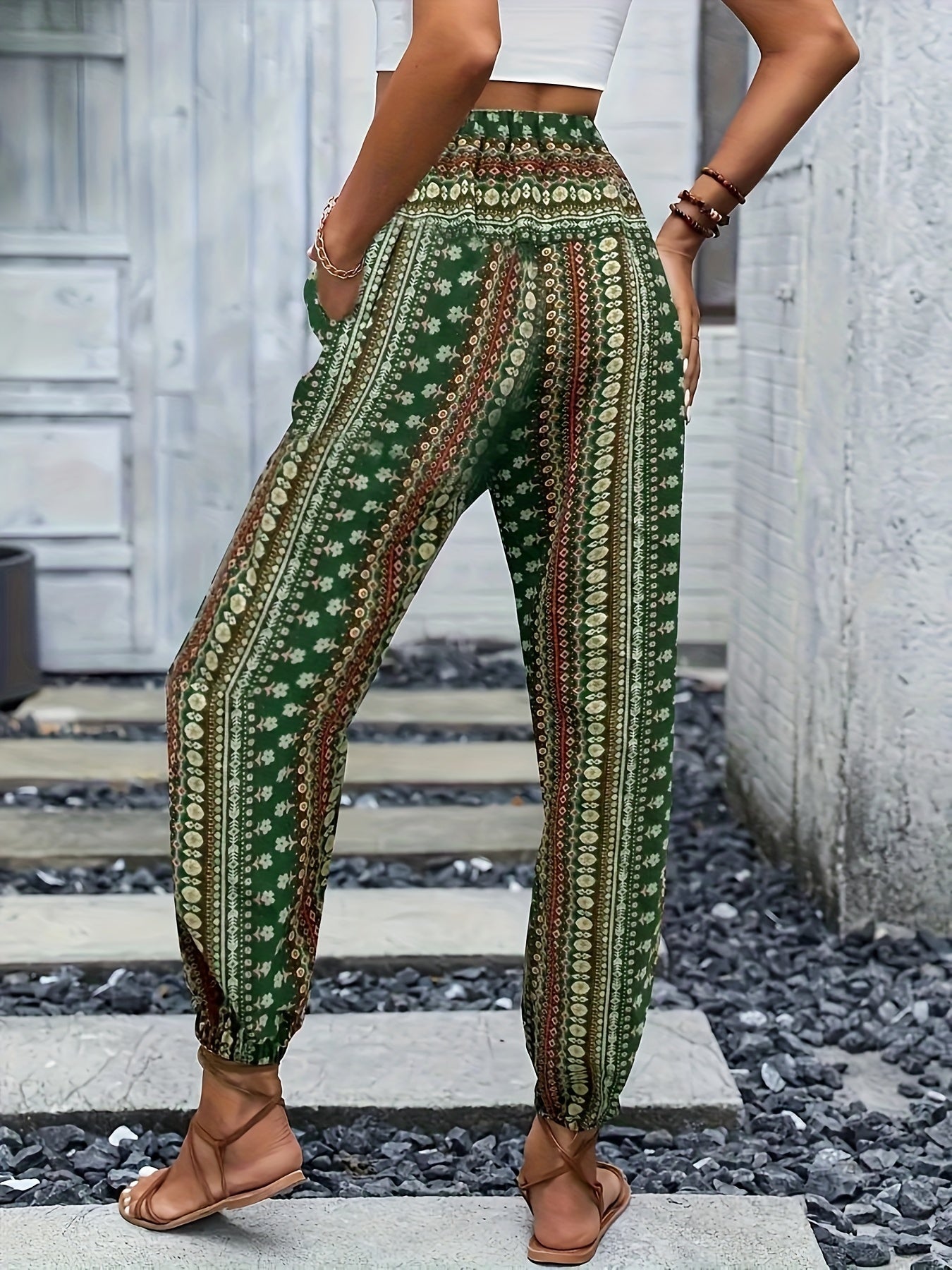 Pantaloni boho verdi a vita alta con stampa floreale, indossati da una donna. Stile casual estivo, perfetti per look rilassati e alla moda.