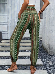 Pantaloni boho verdi a vita alta con stampa floreale, indossati da una donna. Stile casual estivo, perfetti per look rilassati e alla moda.