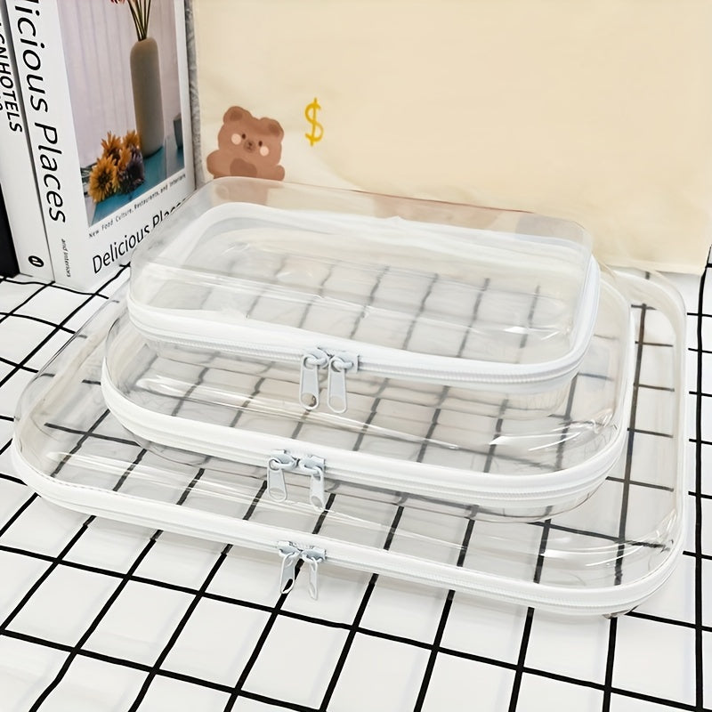 Set di tre borse trasparenti con cerniera, ideali per organizzare cosmetici e accessori da viaggio. Design moderno e pratico, perfetto per valigie.