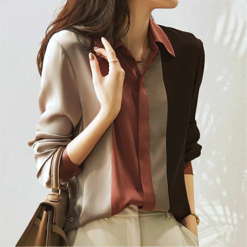 Camicia donna elegante a righe verticali multicolore, maniche lunghe, abbinata a pantaloni chiari. Stile casual chic, moda femminile autunnale.