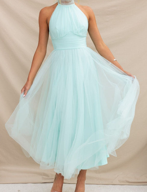 Abito da sera lungo in tulle azzurro, senza maniche, con scollo all'americana. Elegante e ideale per cerimonie e occasioni speciali.
