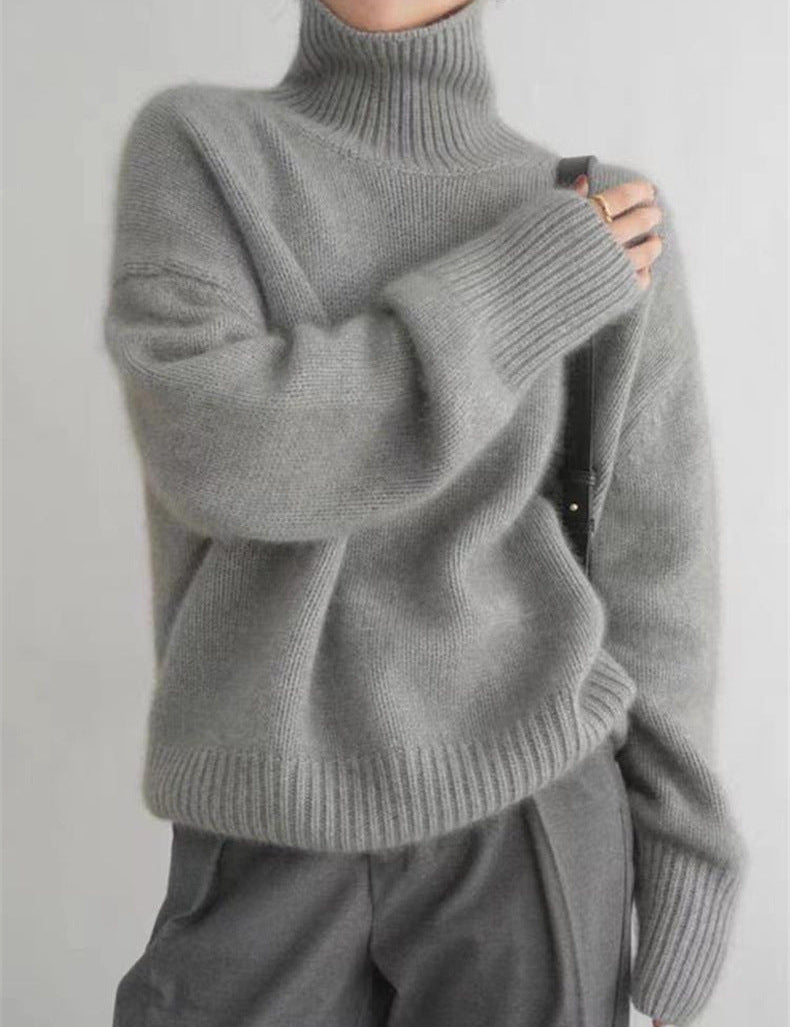 Maglione grigio a collo alto in lana, stile casual, indossato da una persona. Design morbido e caldo, ideale per l'inverno.