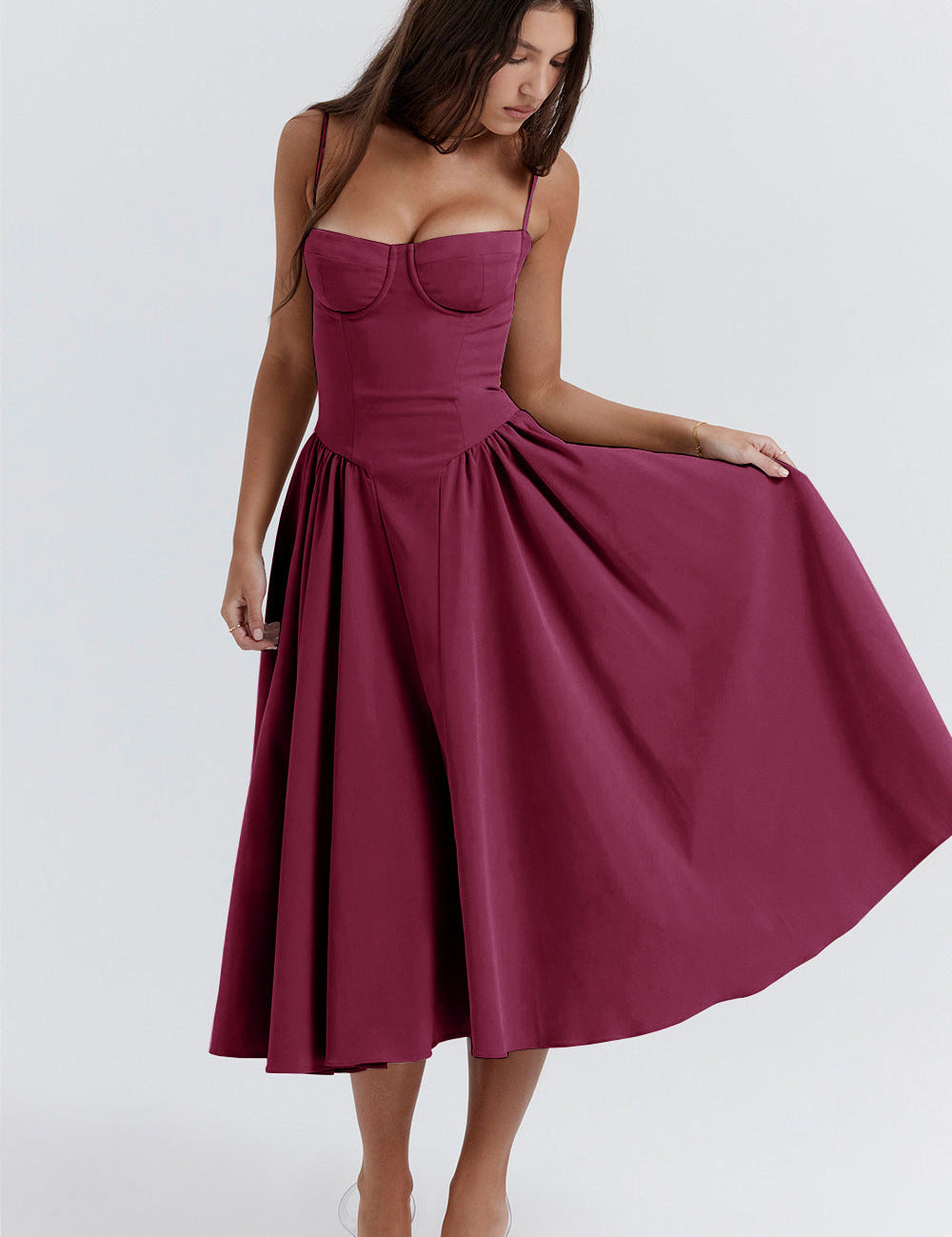 Donna con abito midi bordeaux elegante, spalline sottili, scollo a cuore, gonna svasata. Moda femminile, abbigliamento da sera raffinato.
