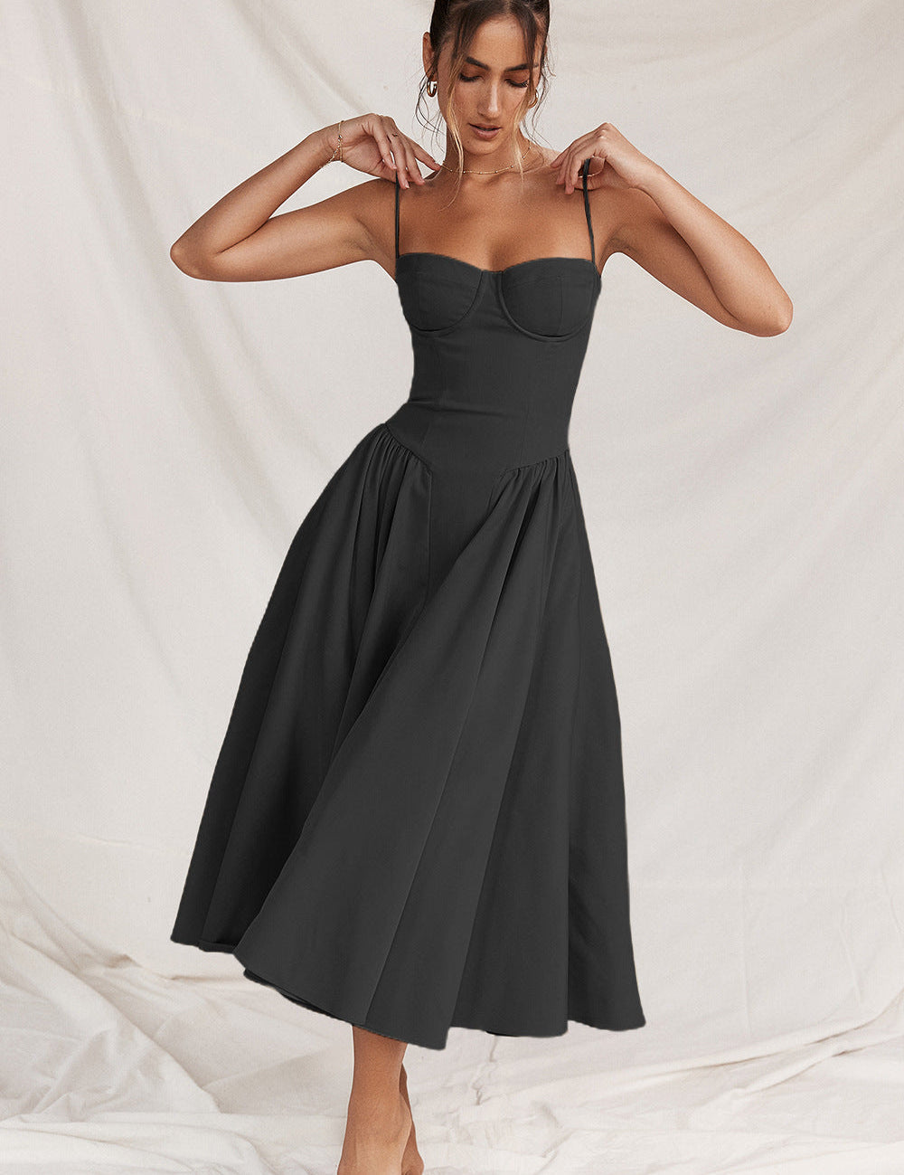 Abito nero elegante donna, lunghezza midi, spalline sottili, scollatura a cuore, perfetto per eventi serali e cerimonie. Moda femminile chic.