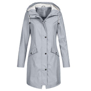Giacca impermeabile donna grigia con cappuccio, chiusura a bottoni, tasche frontali. Elegante e pratica per pioggia e vento.