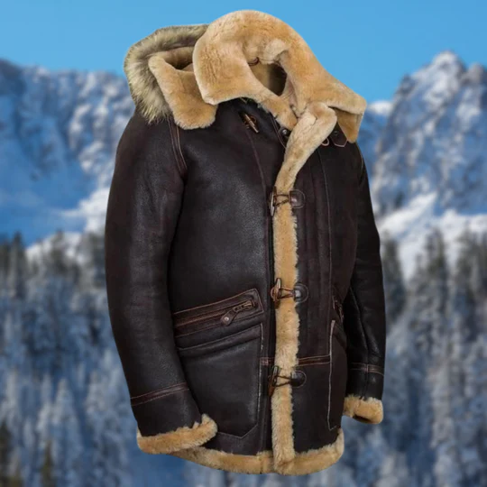 Giacca in pelle marrone con fodera in pelliccia, cappuccio e chiusura a bottoni, ideale per l'inverno. Sfondo montagna innevata.