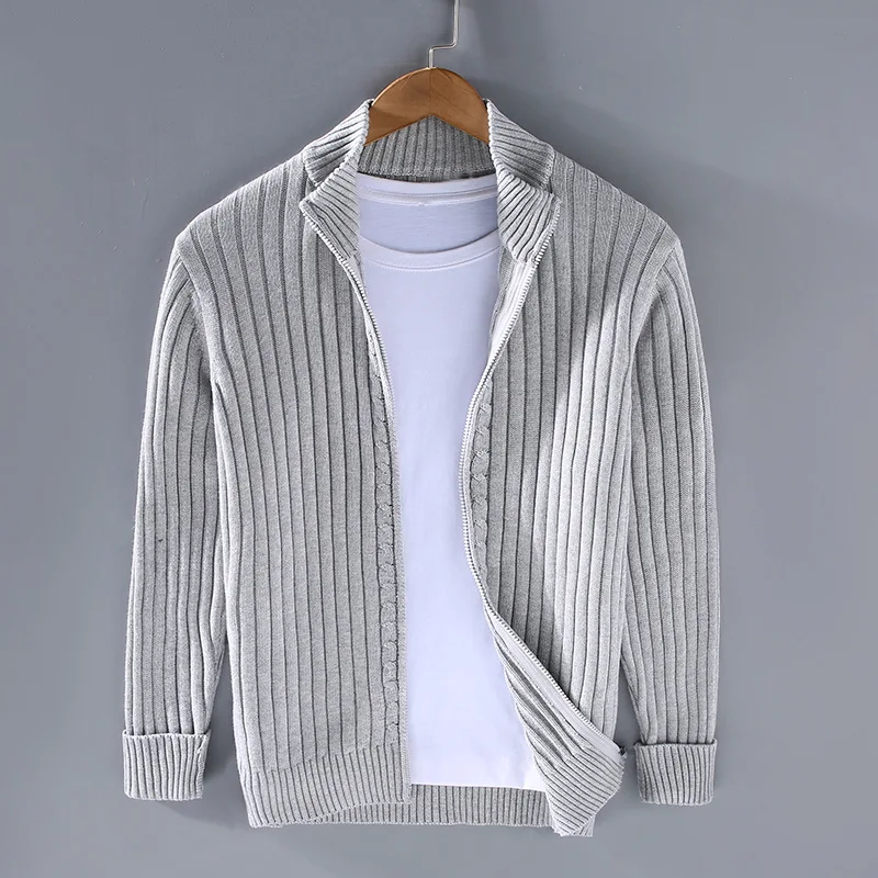 Cardigan grigio a coste su gruccia, abbinato a t-shirt bianca. Moda uomo, abbigliamento casual, maglione leggero, stile autunnale.