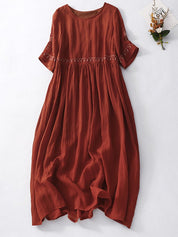 Abito lungo in lino rosso terracotta, maniche corte, dettagli ricamati, stile boho chic, perfetto per l'estate. Moda donna casual elegante.