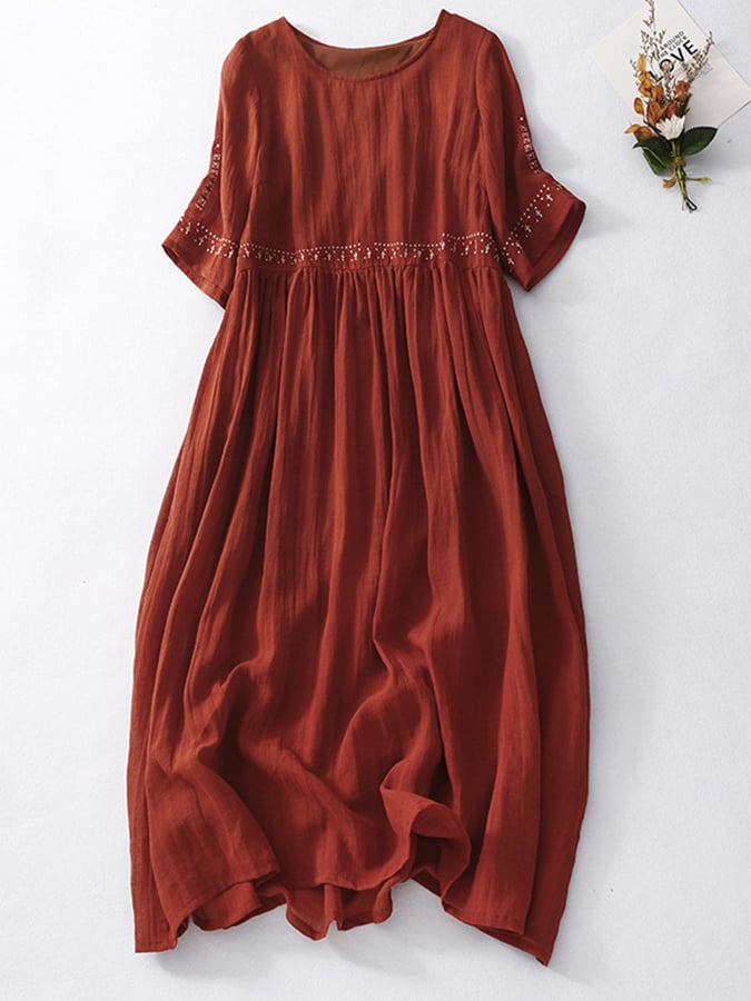 Abito lungo in lino rosso terracotta, maniche corte, dettagli ricamati, stile boho chic, perfetto per l'estate. Moda donna casual elegante.