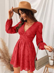 Donna con abito rosso in pizzo, cappello beige, borsa a tracolla, sfondo bianco. Moda femminile elegante, abbigliamento autunnale chic.