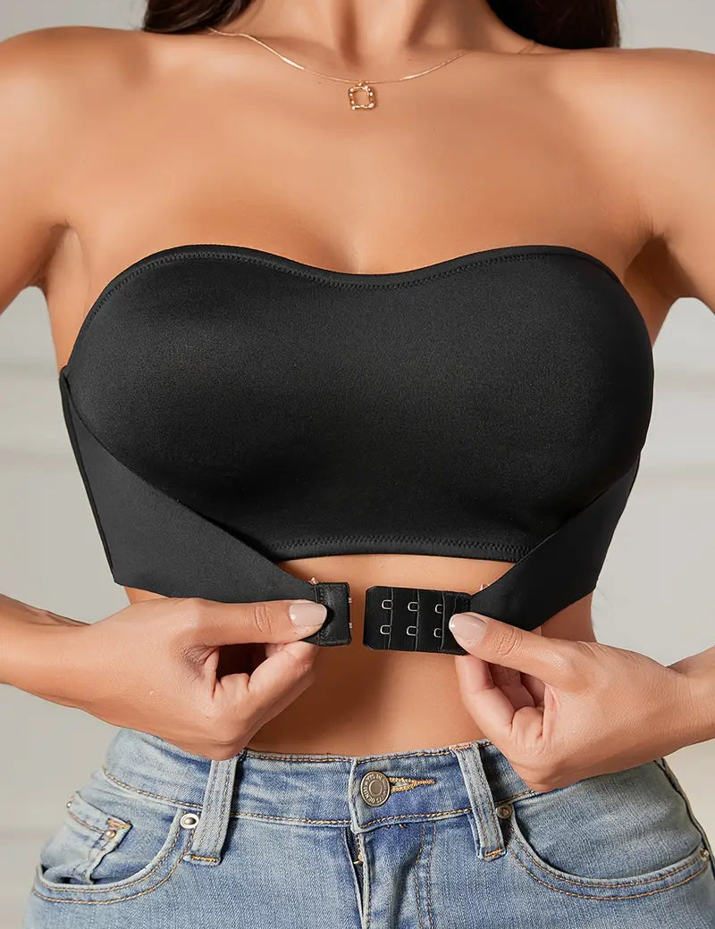 Top nero senza spalline, chiusura frontale a ganci, indossato con jeans. Design elegante e moderno, perfetto per look casual e serate.