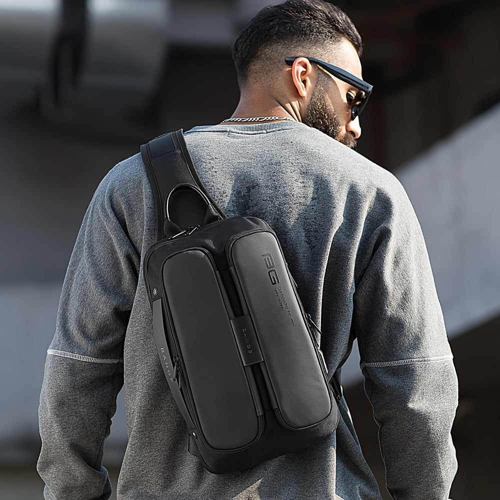 Uomo con zaino a tracolla nero, design moderno, indossa felpa grigia. Accessorio moda urbana, ideale per viaggi e uso quotidiano.