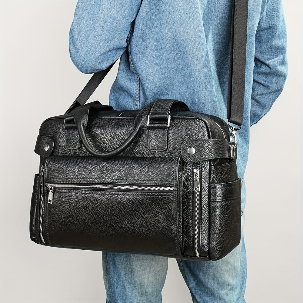 Uomo con borsa da viaggio in pelle nera, tasche con zip, tracolla regolabile, indossa giacca di jeans. Accessorio moda elegante e funzionale.