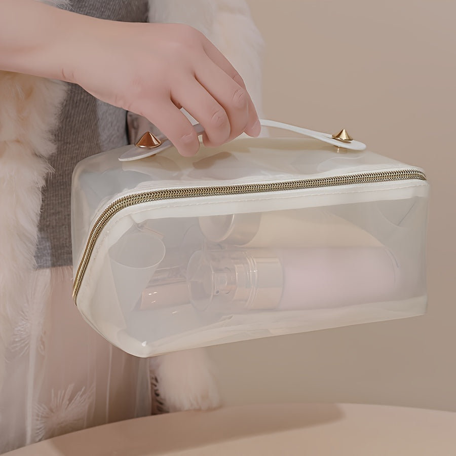 Borsa trasparente da viaggio con cerniera dorata, contenente flaconi cosmetici. Design elegante, ideale per organizzare prodotti di bellezza.