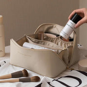 Beauty case beige con prodotti cosmetici, pennelli trucco e flaconi. Organizer trucco elegante per viaggi, accessori bellezza essenziali.
