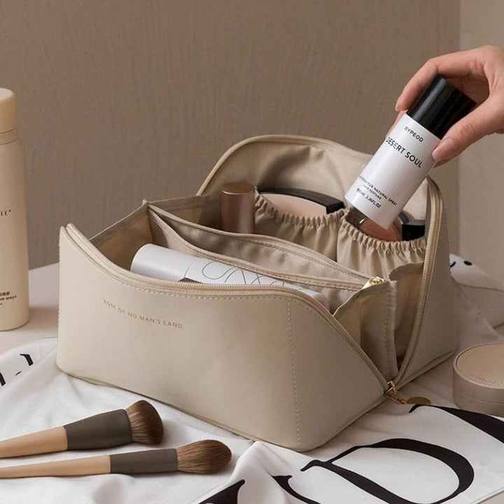 Beauty case beige con prodotti cosmetici, pennelli trucco e flaconi. Organizer trucco elegante per viaggi, accessori bellezza essenziali.