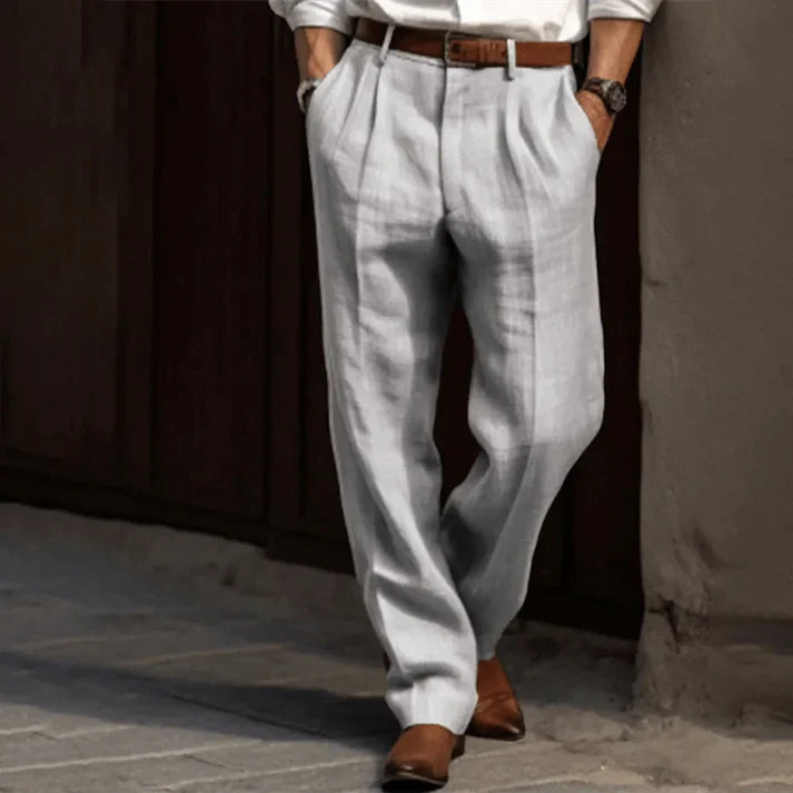 Pantaloni uomo lino grigio chiaro, eleganti e casual, con cintura marrone e scarpe in pelle marrone. Ideali per look estivo raffinato.