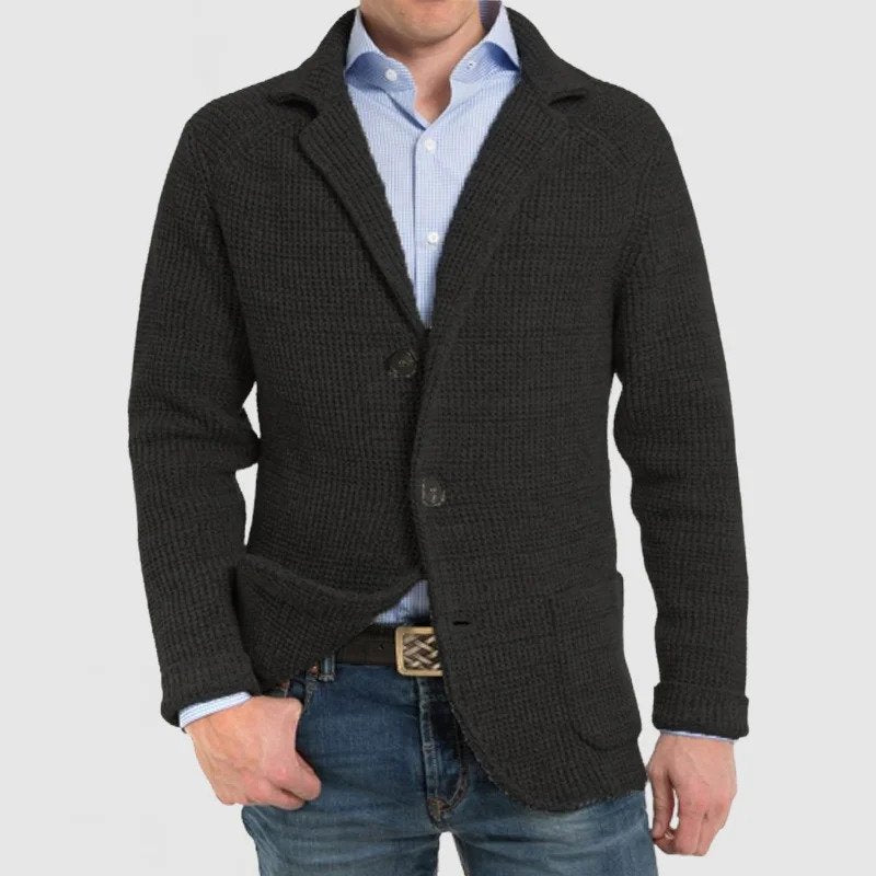 Giacca uomo in maglia nera, stile casual elegante, abbinata a camicia azzurra e jeans. Ideale per moda autunno-inverno.