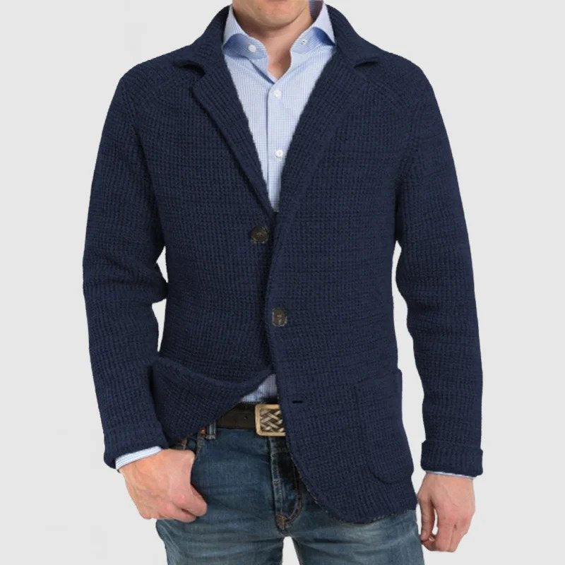Giacca uomo blu scuro in maglia, stile casual elegante, con bottoni e tasche frontali, indossata su camicia azzurra e jeans.