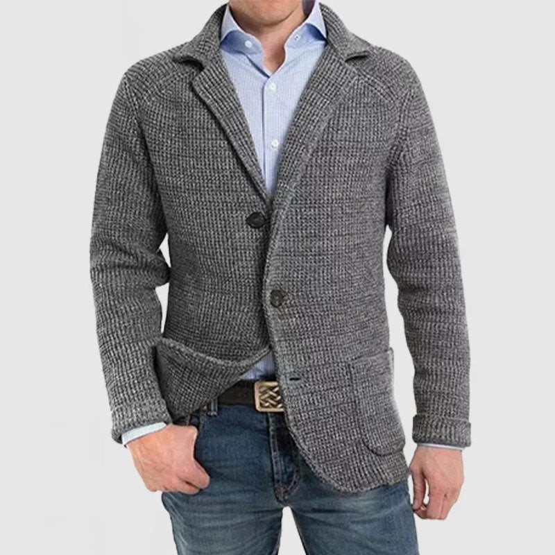 Giacca cardigan uomo grigia in maglia, stile casual elegante, con bottoni e tasche frontali, indossata su camicia azzurra e jeans.