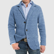 Giacca uomo in maglia blu, stile casual, con bottoni e tasche frontali, indossata su camicia azzurra e jeans. Moda maschile elegante.