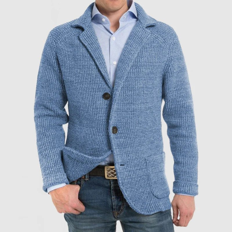 Giacca uomo in maglia blu, stile casual, con bottoni e tasche frontali, indossata su camicia azzurra e jeans. Moda maschile elegante.
