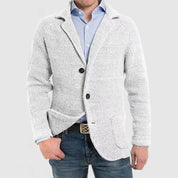 Giacca cardigan uomo grigia, tessuto a maglia, abbinata a camicia azzurra e jeans. Moda casual elegante, abbigliamento maschile autunnale.