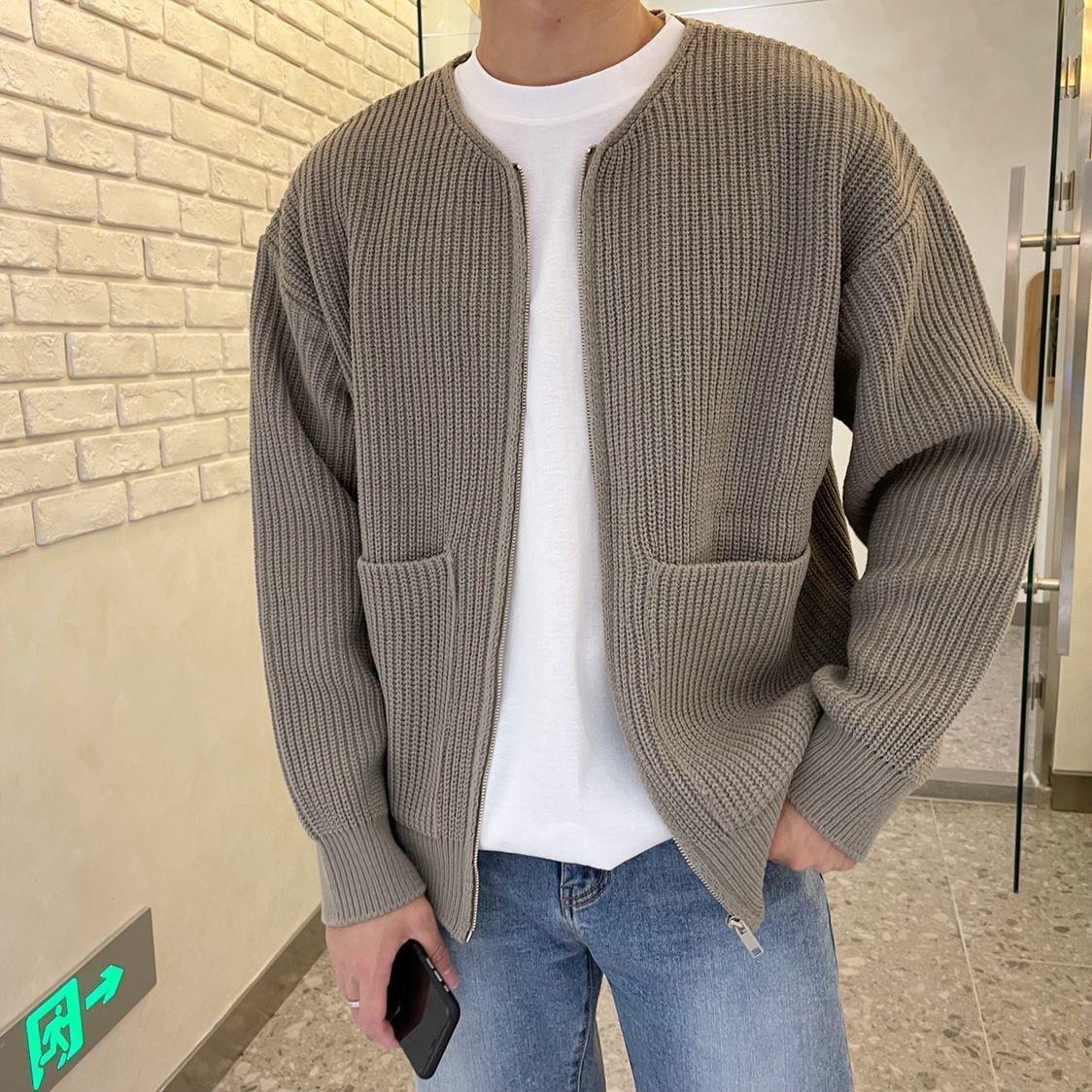 Giacca cardigan uomo in maglia grigia, stile casual, con tasche frontali, indossata su t-shirt bianca e jeans. Moda autunnale maschile.