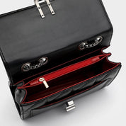 Borsa a tracolla in pelle nera con interno rosso, catena metallica, chiusura a scatto, design elegante. Accessorio moda donna di lusso.