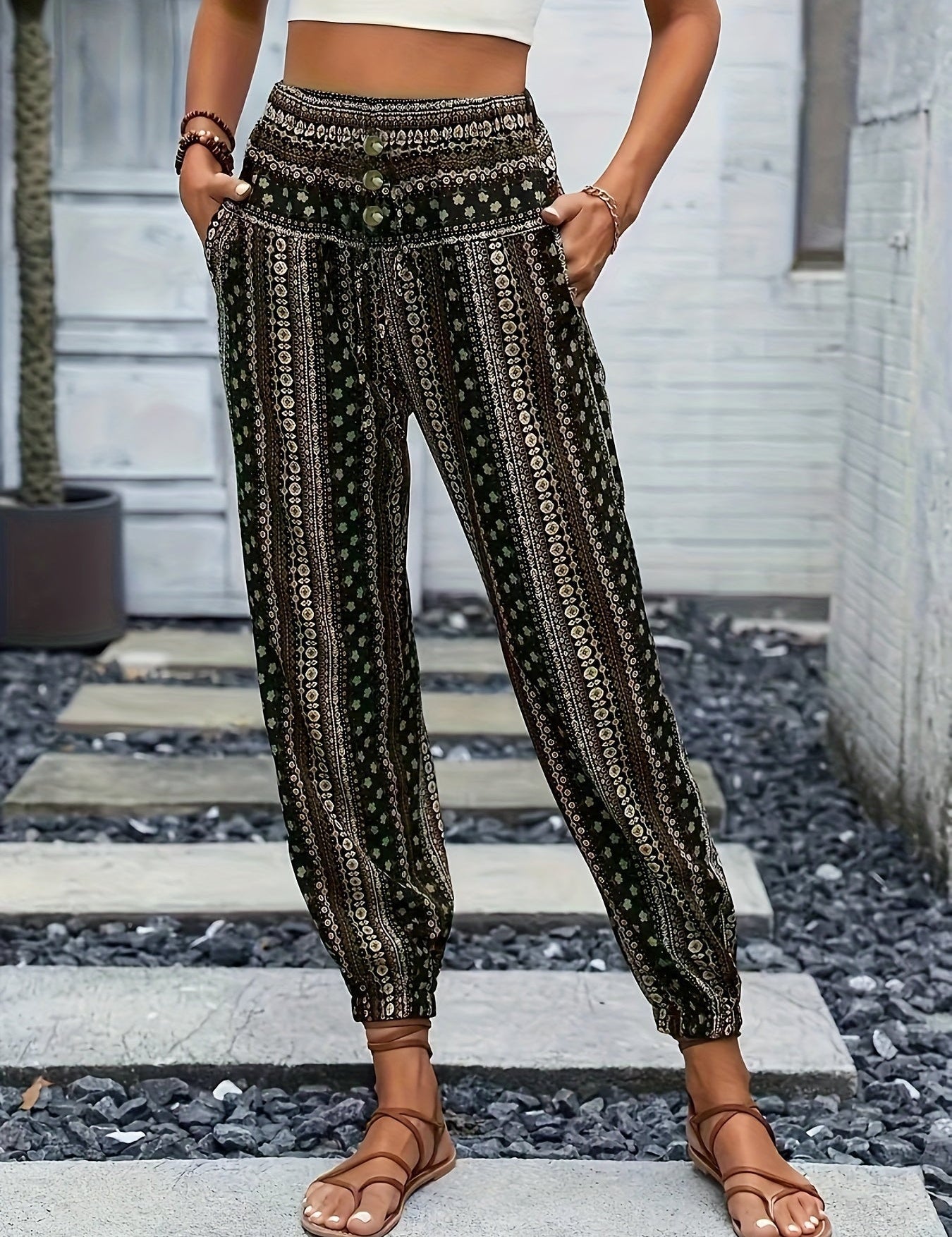 Pantaloni boho donna a vita alta, motivo etnico, tasche laterali, fondo elastico, stile casual estivo, indossati con sandali marroni.