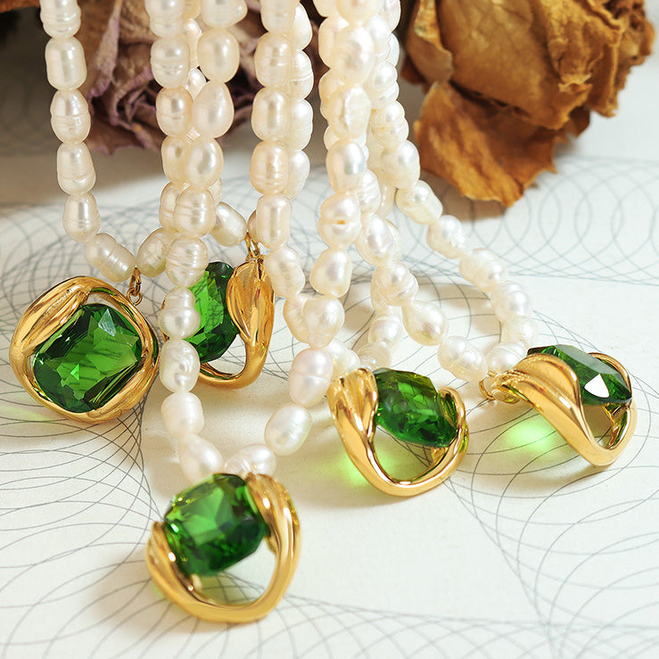 Collana di perle bianche con pendente in cristallo verde e dettagli dorati, elegante gioiello per donna, accessorio moda raffinato.