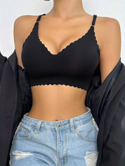 Donna indossa reggiseno nero senza cuciture, spalline regolabili, abbinato a jeans a vita alta. Intimo comodo, moda femminile, stile casual.