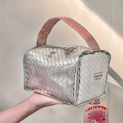 Borsa a mano argentata intrecciata con manico rosa, design moderno e elegante, perfetta per moda femminile e accessori di tendenza.