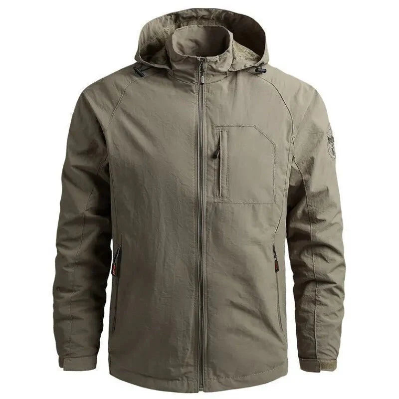 Giacca impermeabile verde oliva con cappuccio, tasche con zip, design casual, ideale per outdoor e trekking. Tessuto resistente e antivento.
