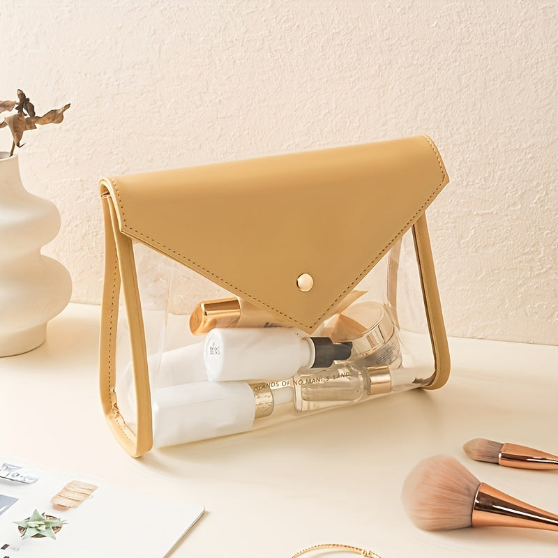 Borsa trasparente in PVC con dettagli in pelle beige, contenente cosmetici e pennelli trucco, su tavolo chiaro. Elegante e pratica per viaggi.