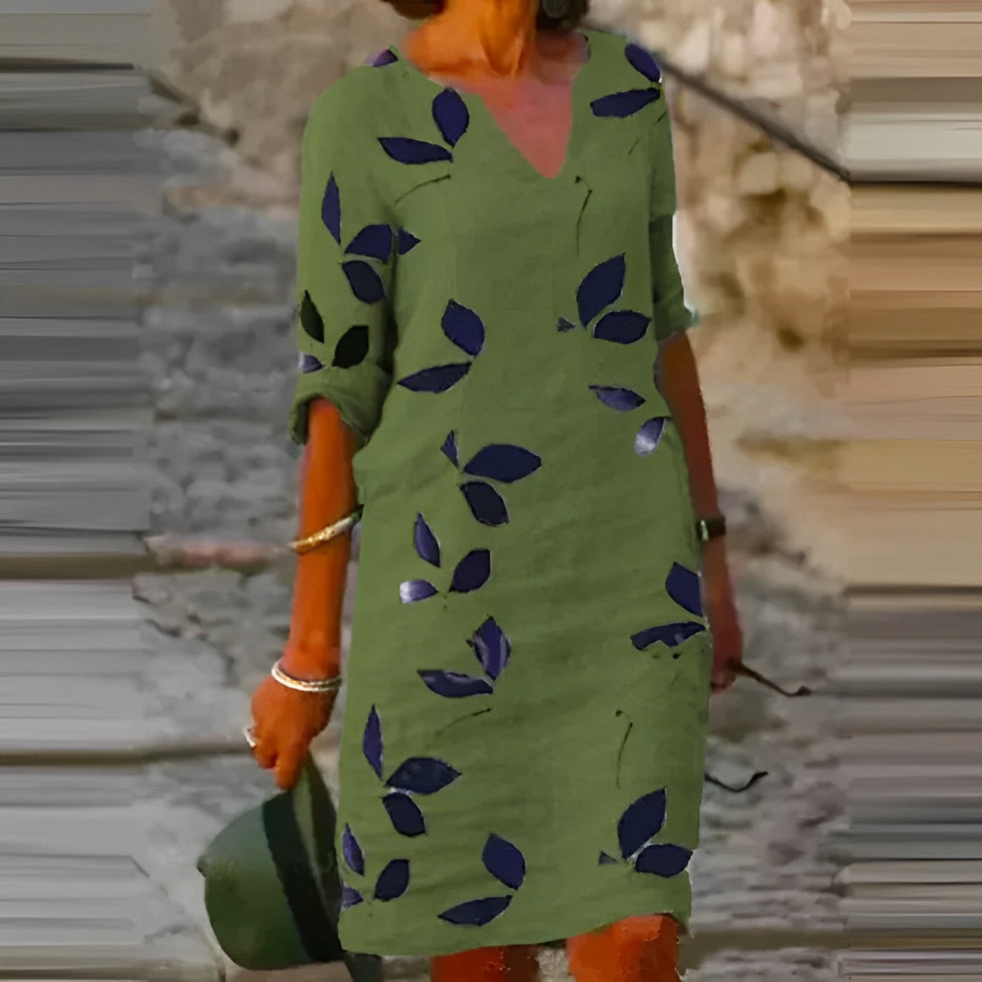Abito verde con motivo a foglie blu, maniche a tre quarti, scollo a V, indossato da donna all'aperto. Moda estiva casual elegante.