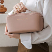 Borsa cosmetica rosa cipria in pelle, elegante e compatta, con cerniera dorata. Ideale per viaggi, organizzazione trucco e accessori.