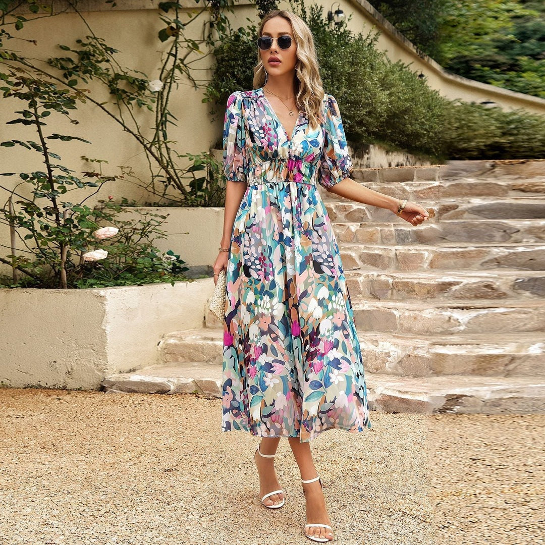 Donna con abito floreale lungo, occhiali da sole e sandali bianchi su gradini di pietra. Moda estiva, abbigliamento femminile elegante.