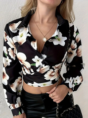 Camicia donna a maniche lunghe con stampa floreale bianca e nera, abbinata a pantaloni in pelle nera. Accessorio: borsa a tracolla.