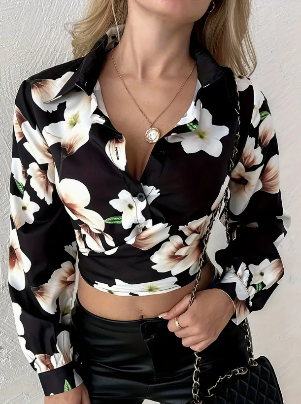 Camicia donna a maniche lunghe con stampa floreale bianca e nera, abbinata a pantaloni in pelle nera. Accessorio: borsa a tracolla.