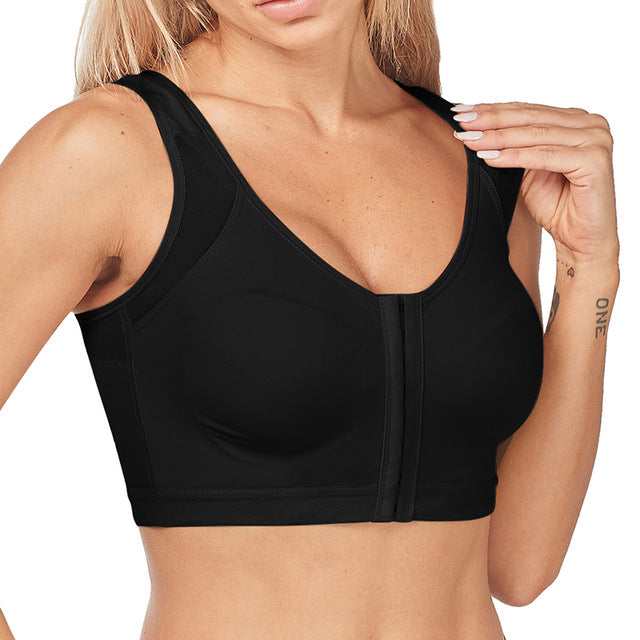 Donna in reggiseno sportivo nero con chiusura frontale, design senza cuciture, supporto elevato. Ideale per fitness, yoga, allenamento.