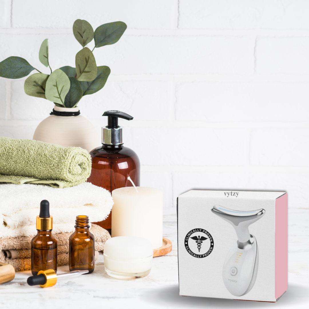 Scatola di massaggiatore viso a forma di Y su tavolo da bagno con asciugamani, candele e flaconi. Cura della pelle, bellezza, benessere.