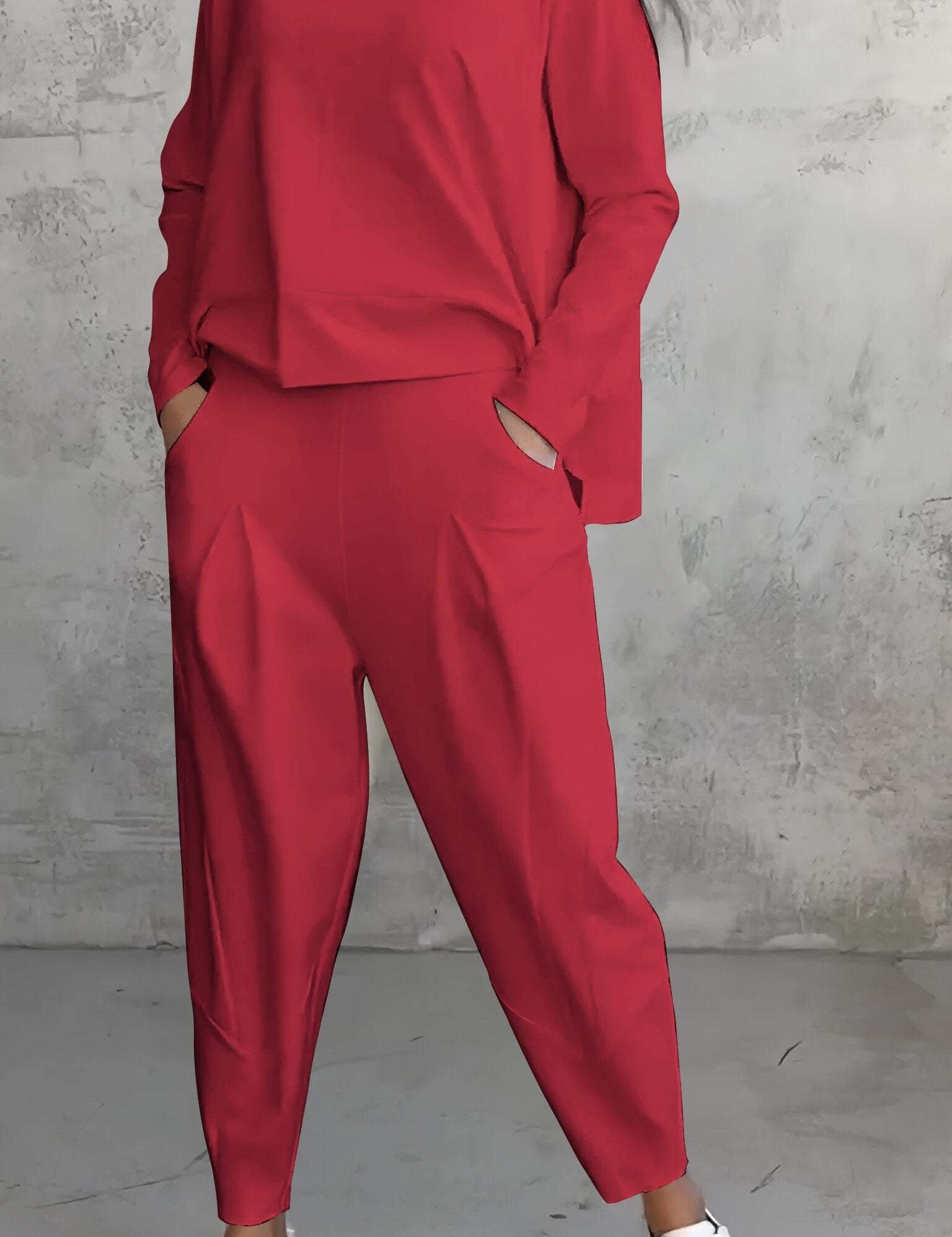 Completo donna rosso elegante, maglia a maniche lunghe e pantaloni larghi, abbinato a sneakers bianche. Moda casual chic, abbigliamento femminile.