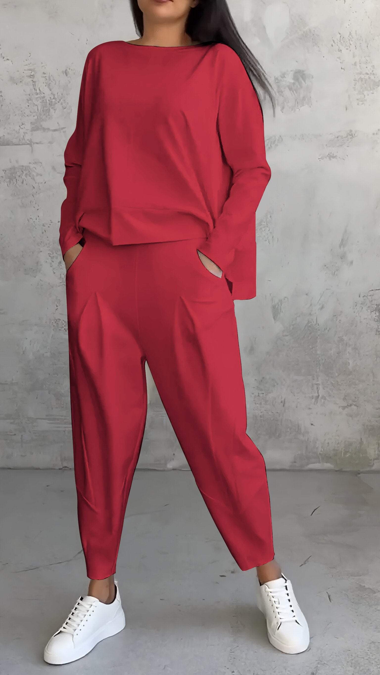 Completo donna rosso elegante, maglia a maniche lunghe e pantaloni larghi, abbinato a sneakers bianche. Moda casual chic, abbigliamento femminile.