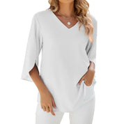 Maglietta bianca da donna con scollo a V, maniche a tre quarti, indossata da modella. Stile casual elegante, perfetta per look estivi e primaverili.