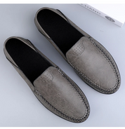 Mocassini uomo in pelle grigia, cuciture a vista, suola nera antiscivolo. Scarpe eleganti e comode, ideali per look casual e formali.