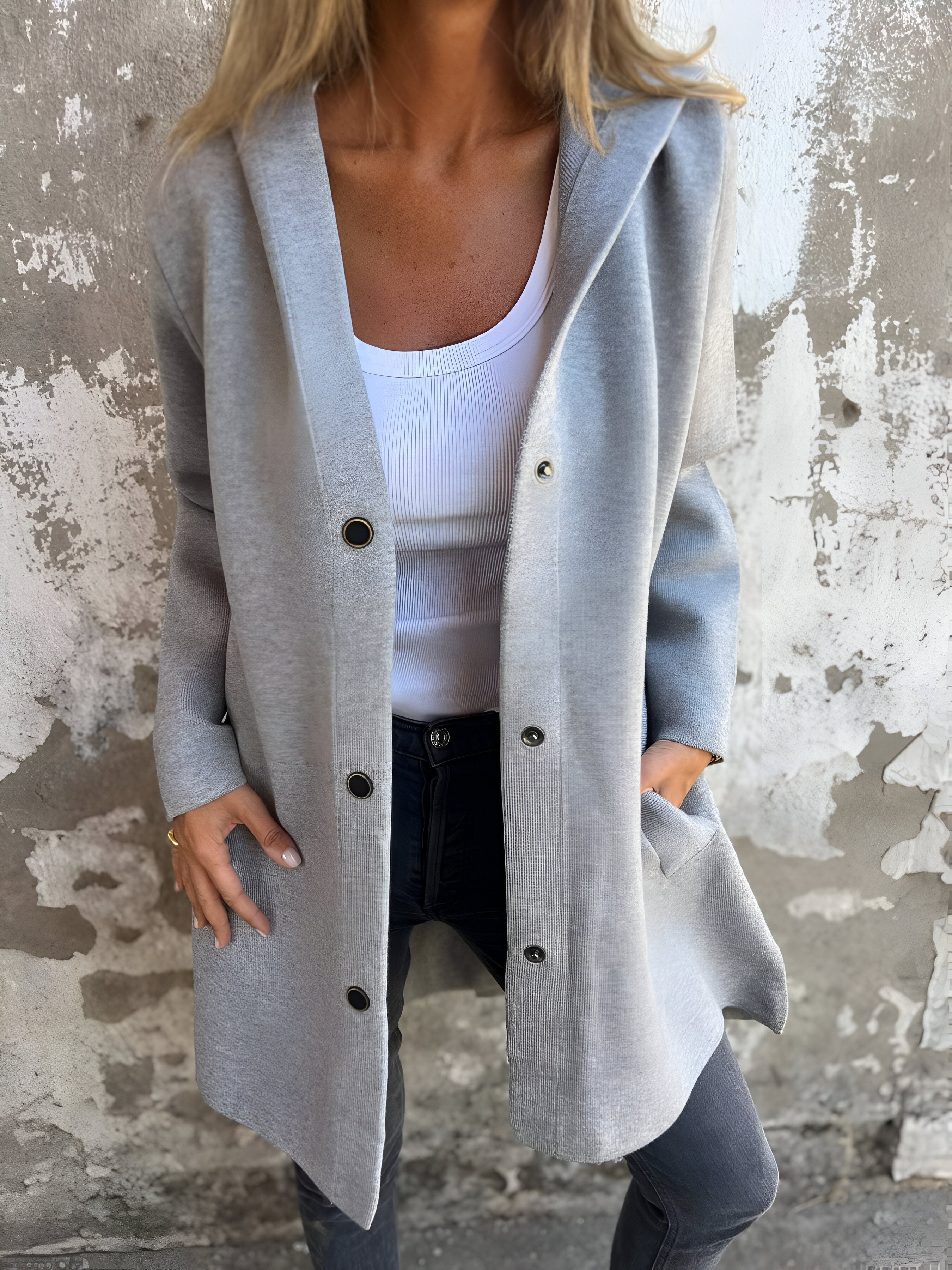 Giacca grigia donna, stile casual, con bottoni e tasche, indossata su top bianco e jeans. Moda autunnale, abbigliamento femminile trendy.