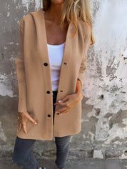 Donna indossa cardigan beige con bottoni neri, top bianco e jeans grigi. Moda autunnale casual, abbigliamento femminile elegante.