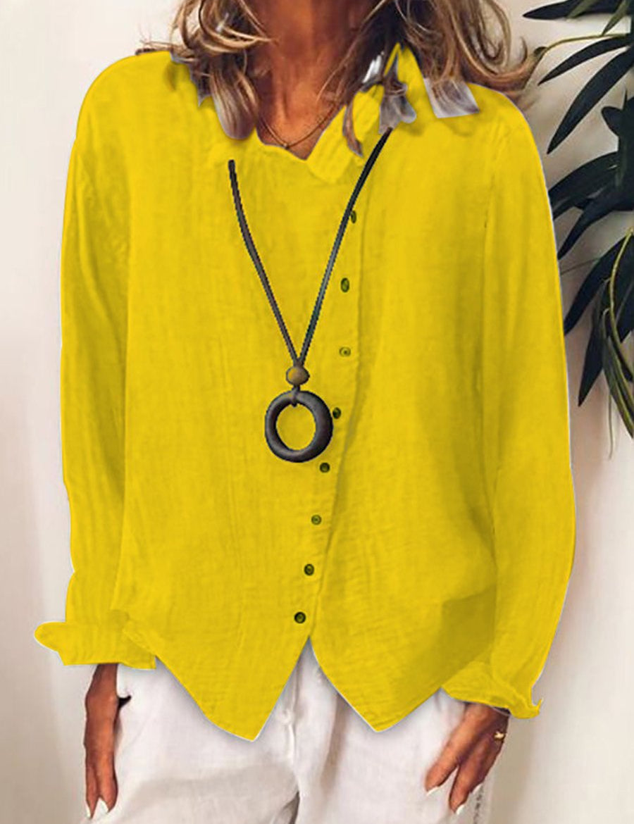 Camicia donna gialla in lino, maniche lunghe, abbinata a collana nera con ciondolo rotondo. Look casual estivo, moda femminile elegante.