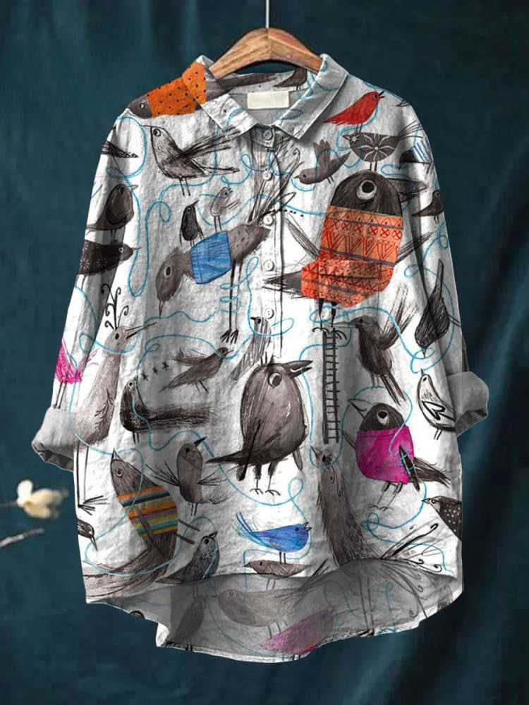 Camicia donna con stampa uccelli colorati, maniche lunghe, colletto classico, design artistico su sfondo bianco, moda casual elegante.